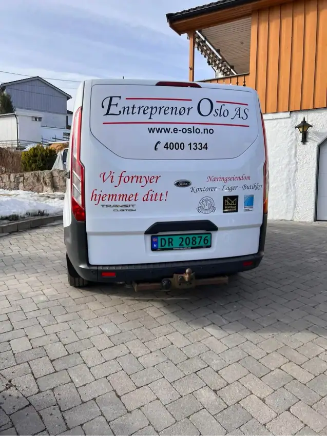 Firmaets varebil med logo for Oslo Entreprenør Service, parkert foran hus.